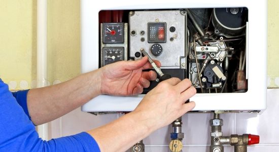 A Hydrofix Plumbing technician performs maintenance on a gas boiler as part of our Auckland plumbing repairs service